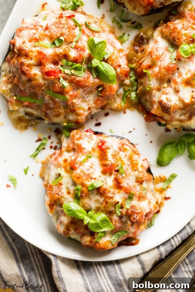 Gourmet Sausage Stuffed Portobellos 8 A selection of baked sausage stuffed portobello mushrooms arranged appealingly on a platter.