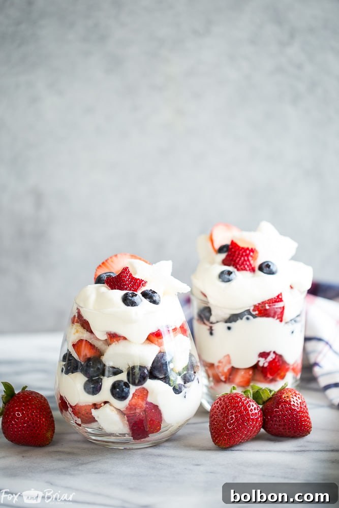 Close-up of a Red, White, and Blue Trifle, showcasing layers of angel food cake, macerated strawberries, blueberries, and homemade whipped cream.