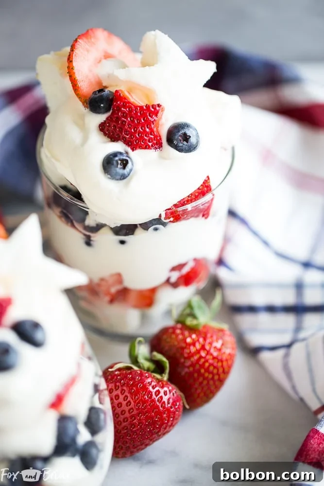 Red, White, and Blue Trifles in glasses, garnished with star-shaped fruit and cake, ready for a summer celebration.