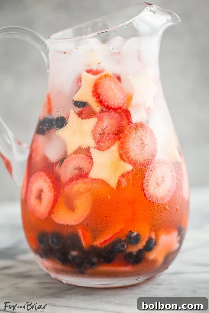Kırmızı, Beyaz ve Mavi Şarap Punçları 3 Close-up of Red, White, and Blue Wine Sparklers in a glass, showcasing the colorful fruit and bubbly texture, ideal for patriotic holidays.