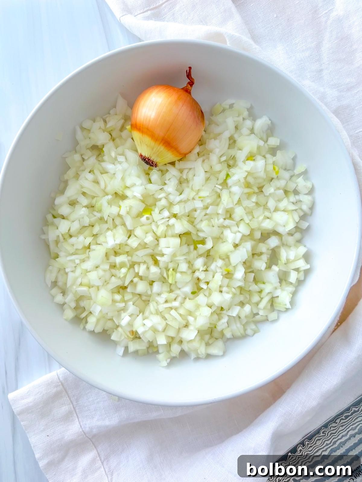 How to Dice Onion - Bowl of perfectly diced onions, illustrating a step-by-step onion cutting tutorial for home chefs.