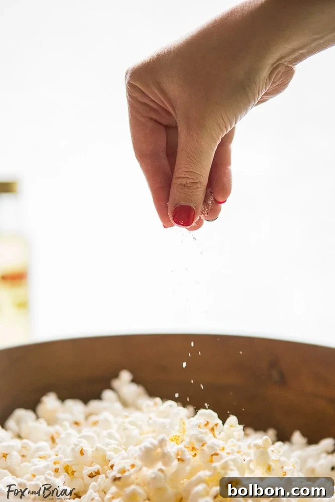 A bowl of freshly popped truffle popcorn, garnished with herbs and a drizzle of truffle oil, ready to be enjoyed. | stovetop popcorn recipe | truffle seasoning ideas | gourmet snack food