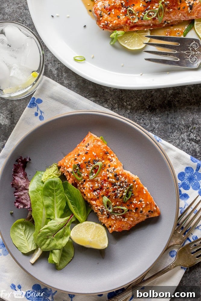 Sweet Chili Garlic Glazed Salmon 7 A close-up of the finished Baked Sweet Chili Garlic Salmon, garnished with sesame seeds and green onions. This healthy, quick, and easy 20-minute recipe is packed with sweet, tangy, and spicy Asian flavors. | Family Dinner | Quick Meal | Healthy Salmon Dinner | Asian Flavors
