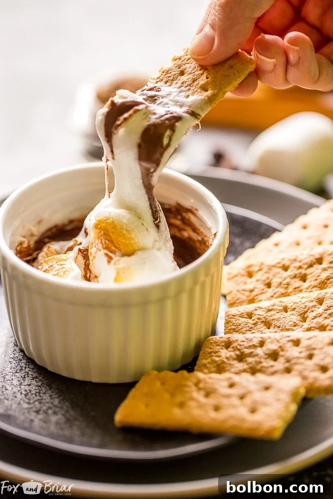 One-Minute S'mores Dip for One, showing the melted chocolate base with marshmallows beginning to puff up. Microwave dessert tips, quick chocolate treats, easy marshmallow dip.