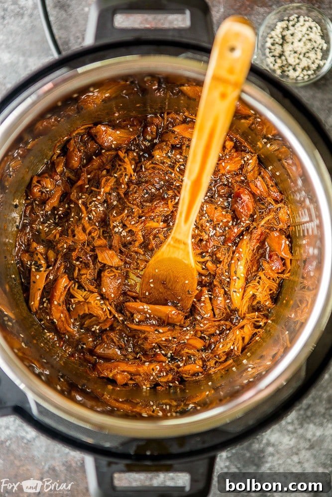 Close-up of tender chicken thighs coated in a rich honey sesame sauce, cooked in an Instant Pot.