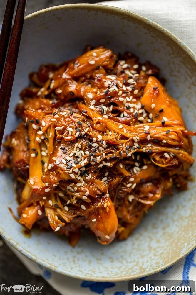 A full Instant Pot filled with the cooked Honey Sesame Chicken, garnished with sesame seeds and green onions, ready to be served.