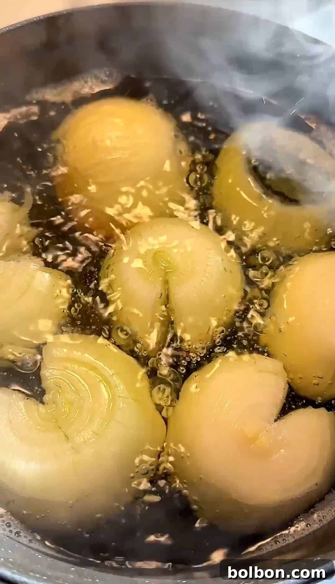 Golden Stuffed Onion Delights 10 Onions are boiling in a pot of water, with steam rising above. The water is bubbling vigorously around the onions, which are partially submerged and creating a visual of cooking in progress.