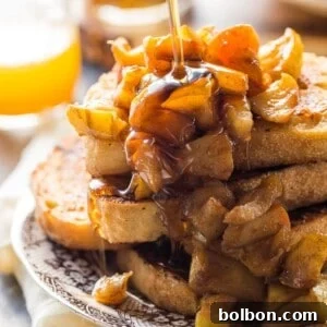 A finished plate of Apple Pie French Toast topped with compote and maple syrup.