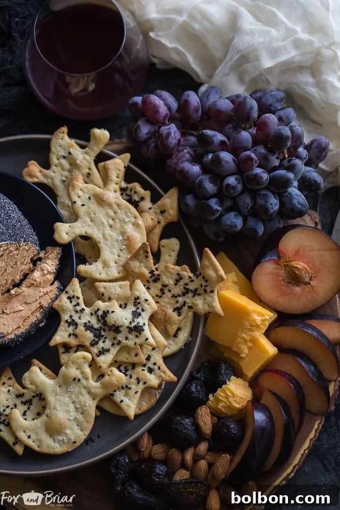 Spooktacular Surprise Crackers 2 Assortment of freshly baked bat and ghost shaped Parmesan crackers on a white plate, perfect for Halloween appetizers