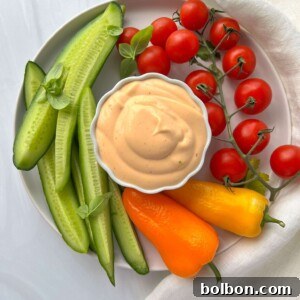 A beautifully presented dish featuring fresh vegetables and a bowl of homemade spicy mayo, emphasizing its versatility and vibrant appeal.