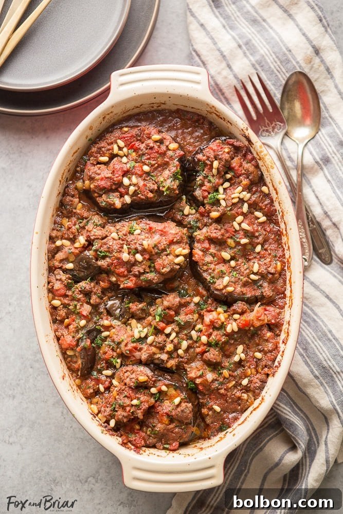 Hearty and flavorful Meat Stuffed Eggplant (Bitten Jen), a low-carb and gluten-free Syrian lamb dinner with rich tomato sauce and toasted pine nuts.
