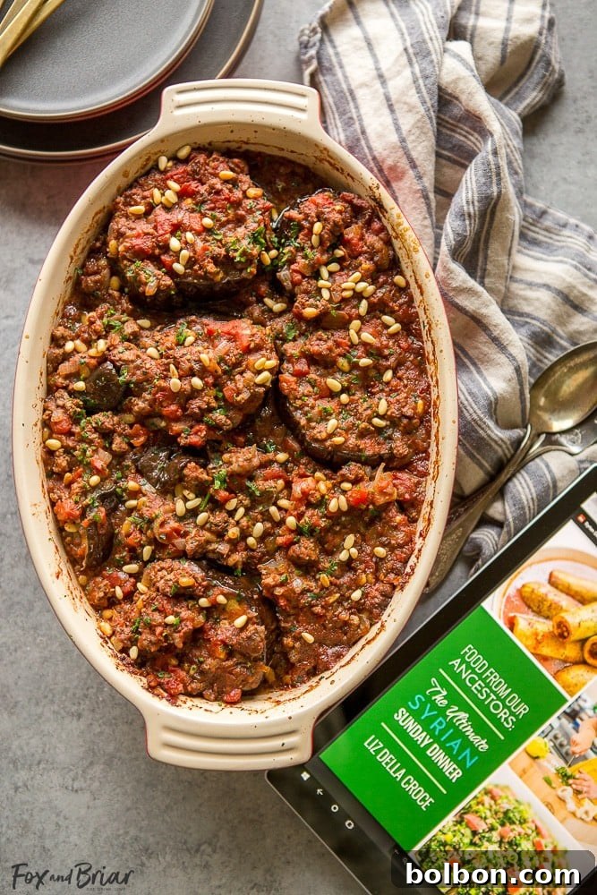 Final presentation of Syrian Meat Stuffed Eggplant (Bitten Jen) garnished with fresh parsley and extra pine nuts, ready to be served with a side of yogurt.