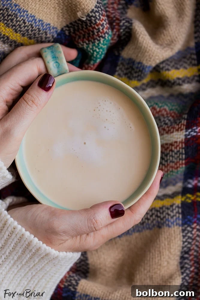 Hands wrapped around a warm, steaming mug of homemade chai, symbolizing comfort and relaxation