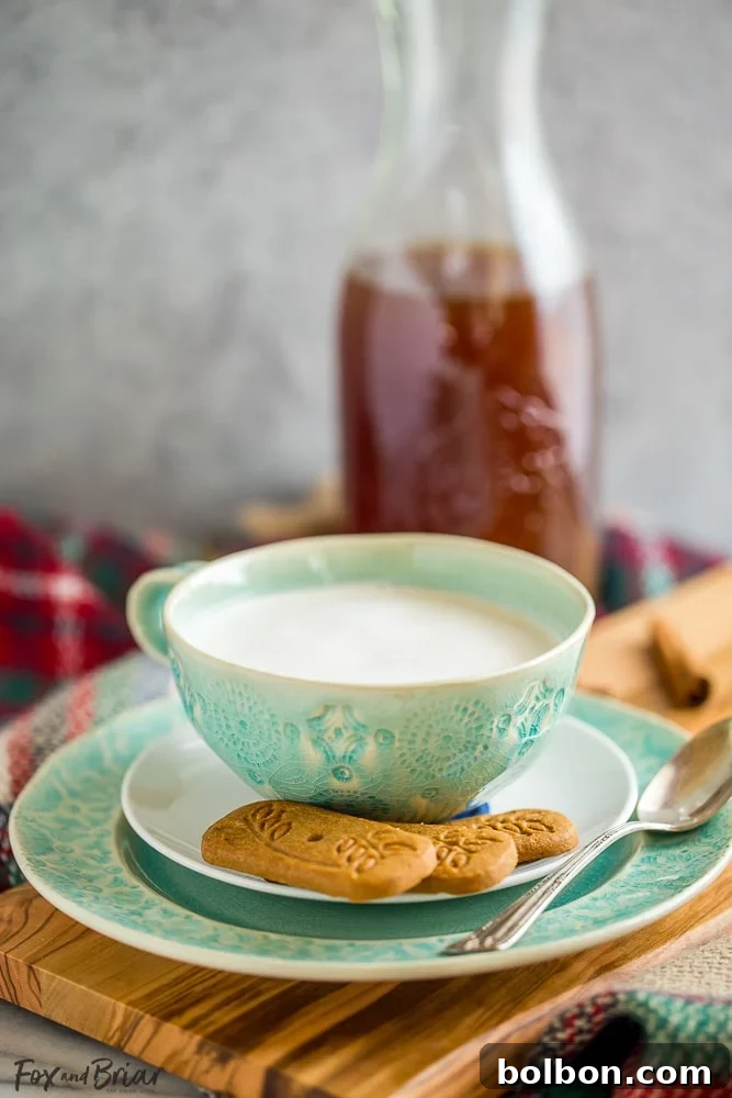 A beautifully crafted ceramic mug of chai tea latte, accompanied by delicious shortbread cookies, symbolizing pure comfort and indulgence
