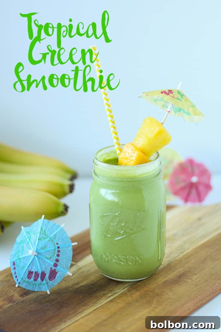A refreshing glass of Tropical Green Smoothie garnished with fresh mint.