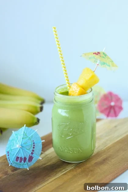 Ingredients for a Tropical Green Smoothie laid out, including spinach, banana, pineapple, and mango.