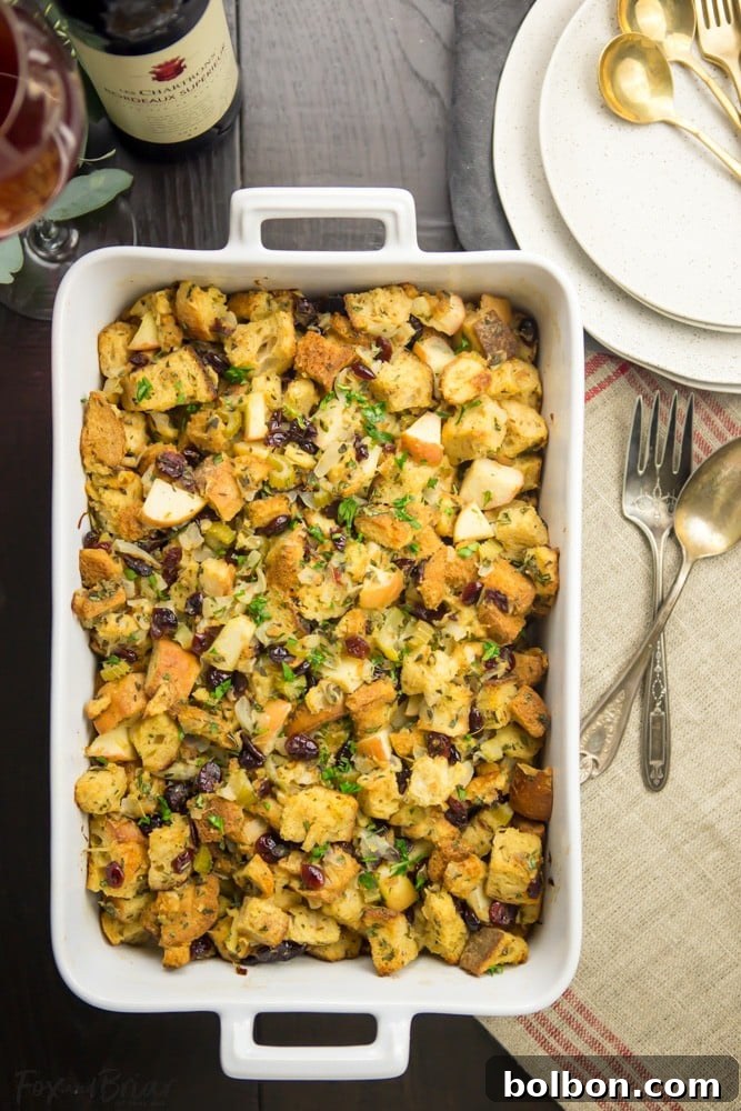 Beautifully baked Cranberry Apple Stuffing, golden brown and garnished with fresh herbs