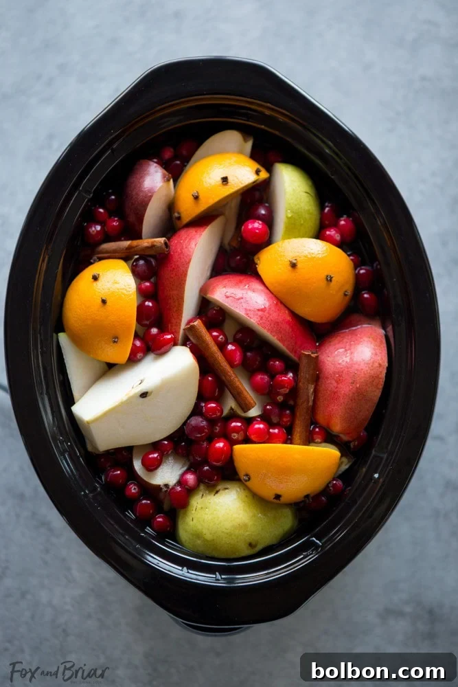 Close-up of a rustic pitcher filled with homemade cranberry pear cider, ready to be served.