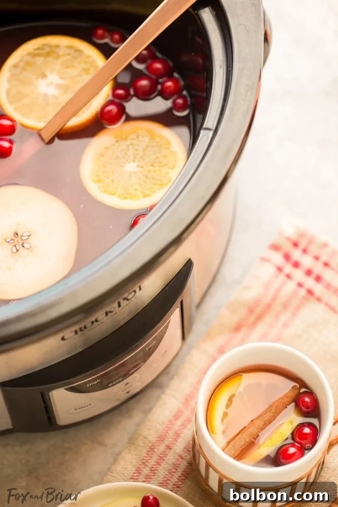 Close-up of a mug of steaming cranberry pear cider, ready to be enjoyed on a chilly day.