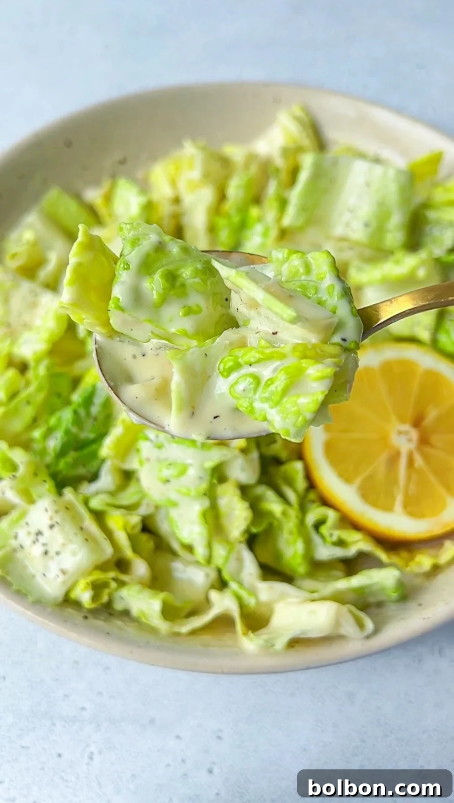 Freshly prepared Caesar Salad with creamy dressing and parmesan, garnished with lemon