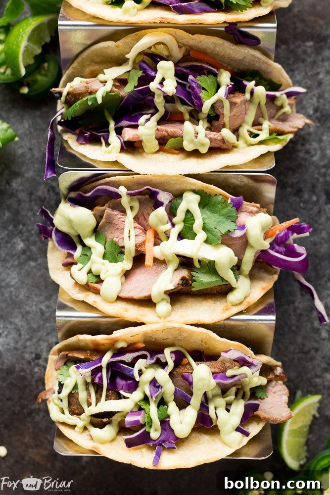 Delicious Honey Lime Steak Tacos drizzled with creamy avocado crema, ready to be enjoyed.