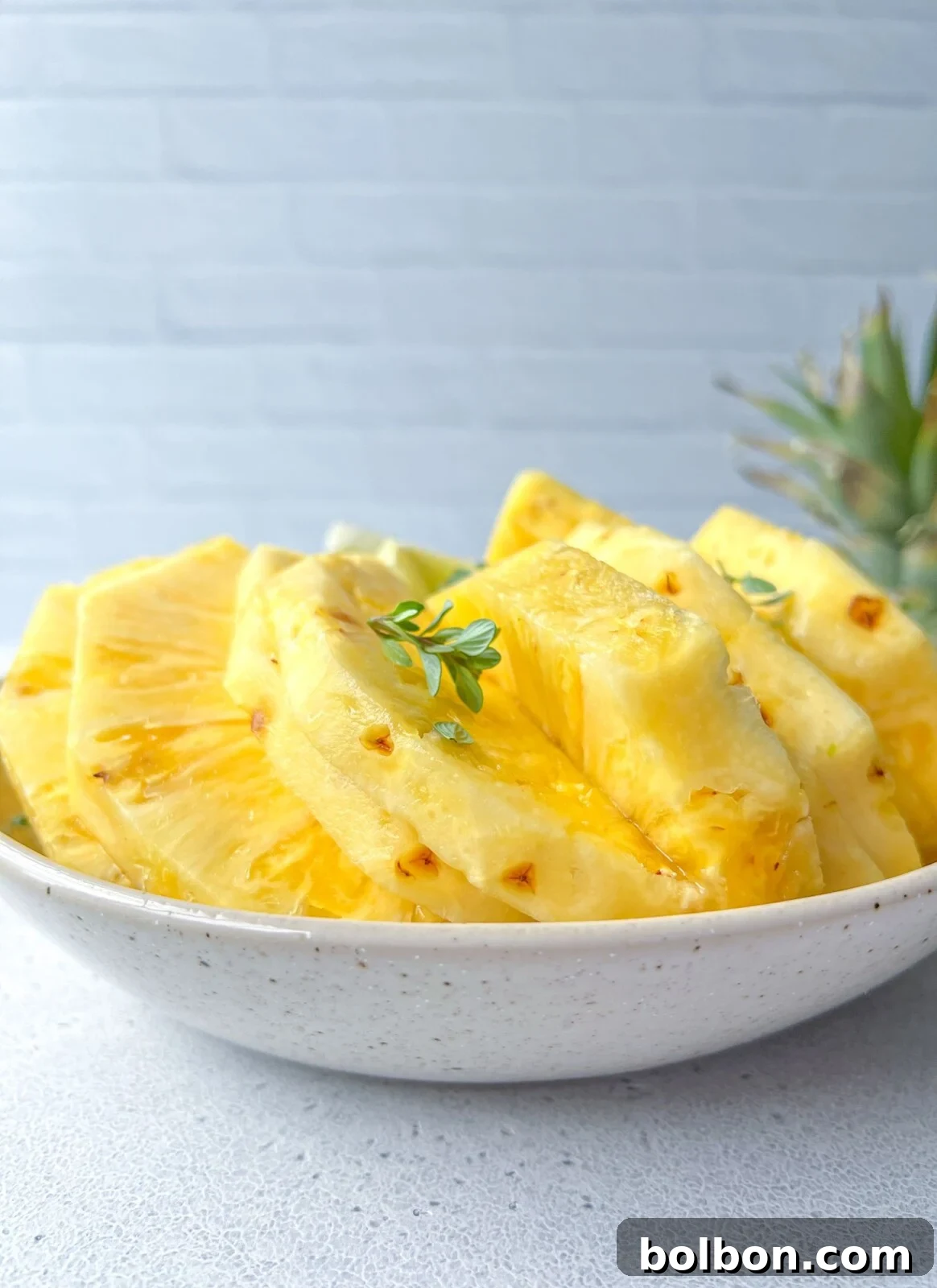 Fresh pineapple sliced on plate with step-by-step cutting guide