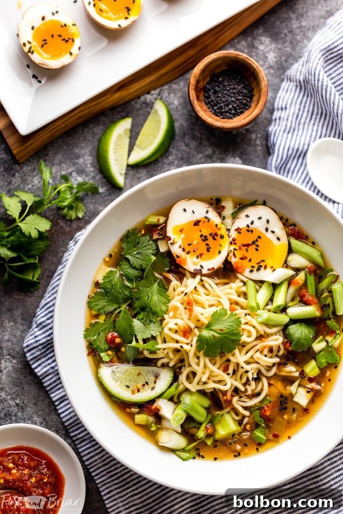 A vibrant bowl of Instant Pot Chicken Ramen, garnished with sliced green onions and a perfectly cooked ramen egg, ready to be enjoyed. The rich broth and tender ingredients promise a comforting meal.