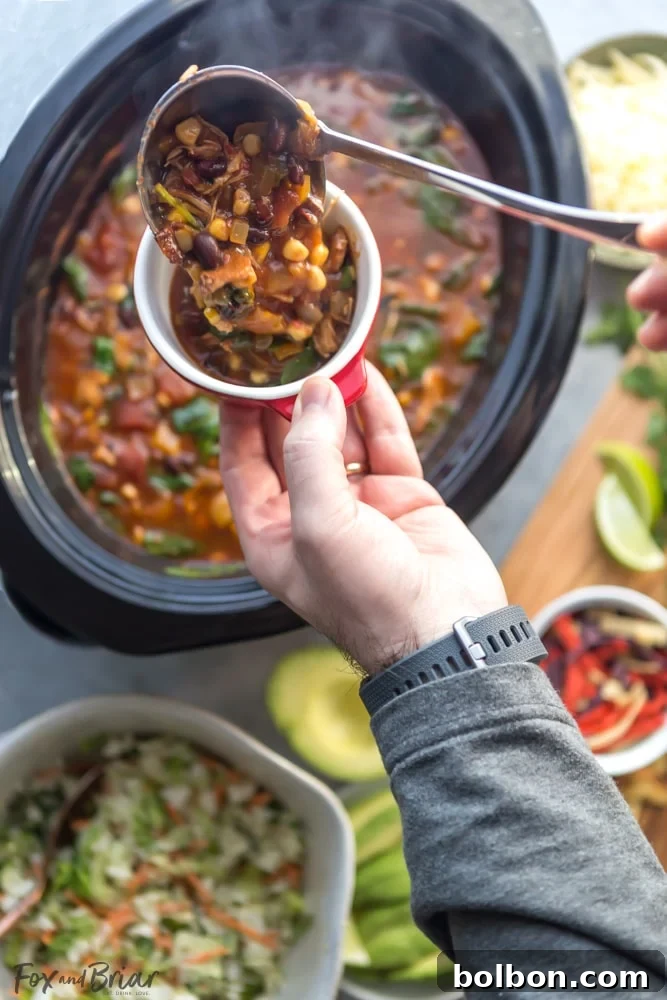 Wholesome Slow Cooker Chicken Tortilla Soup with a Fresh Southwest Salad 5 A vibrant bowl of chicken tortilla soup, richly garnished, accompanied by a fresh Taylor Farms Southwest Chopped Salad kit.