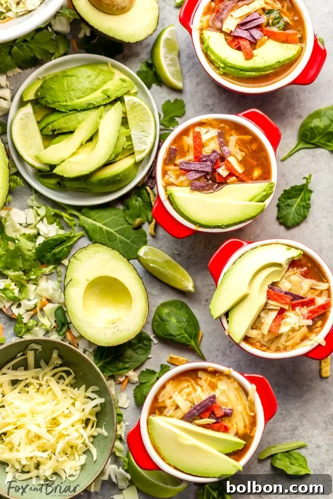 Wholesome Slow Cooker Chicken Tortilla Soup with a Fresh Southwest Salad 9 A vibrant spread of delicious toppings for chicken tortilla soup: sliced Mission Avocados, shredded cheese, crispy tortilla strips, and fresh lime wedges.