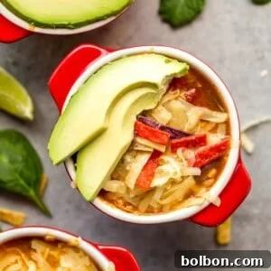 Wholesome Slow Cooker Chicken Tortilla Soup with a Fresh Southwest Salad 10 Healthy Slow Cooker Chicken Tortilla Soup in a white bowl with toppings and a fresh lime.