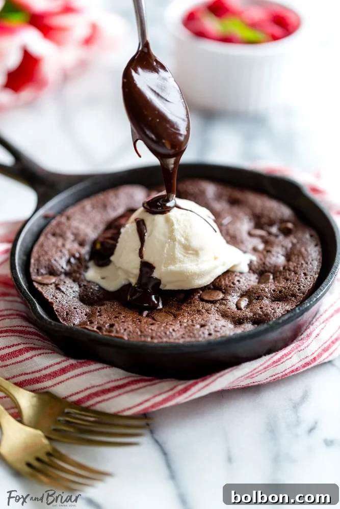 A close-up shot of the raspberry swirl brownie batter in a skillet before baking, showing ribbons of fruit preserve.