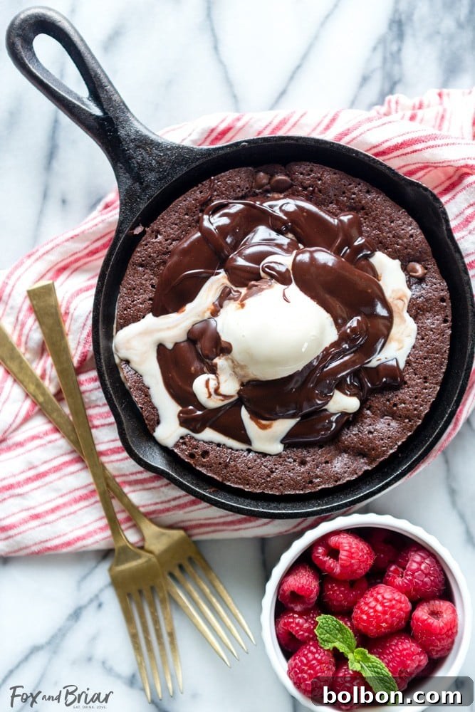 Delicious brownie sundae served in a skillet, with melted ice cream and rich chocolate sauce.