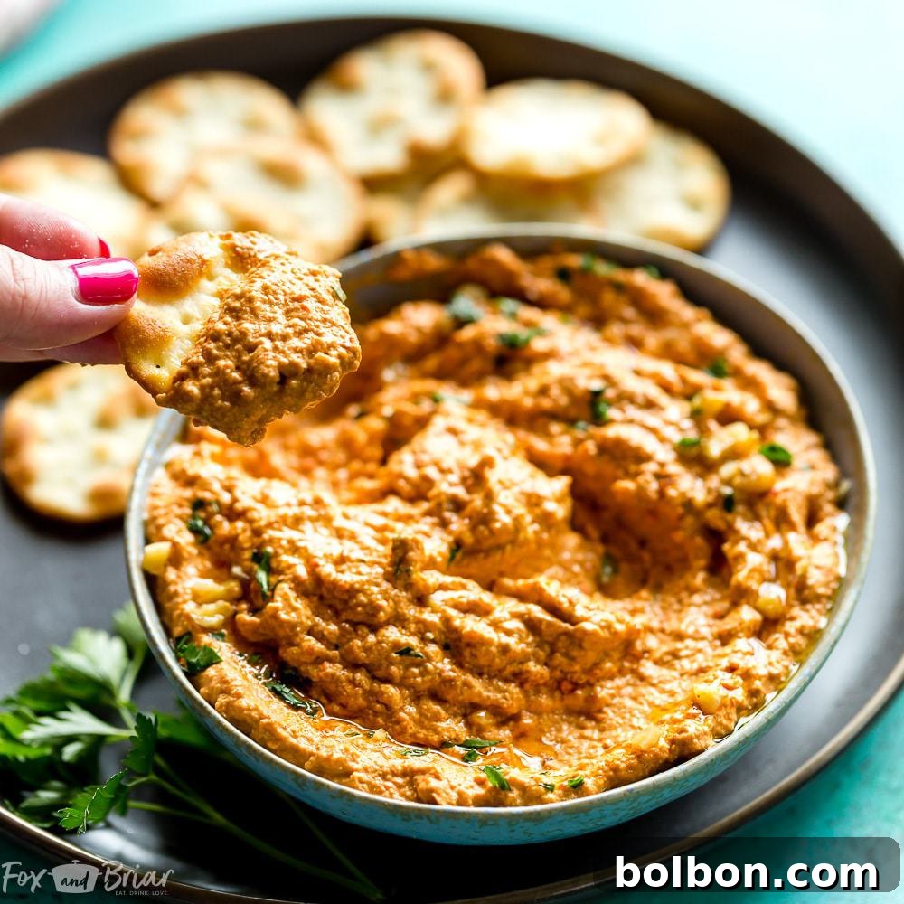 Vibrant Muhammara Roasted Red Pepper and Walnut Dip 8 A close-up of a beautifully textured Muhammara dip in a rustic bowl, highlighted by natural light, showing its delicious appeal as a healthy, versatile Middle Eastern dip.