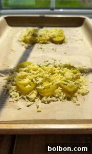 Jalapeño Hype Sandwich 5 Sliced jalapeños topped with shredded cheese are arranged on parchment paper on a baking tray, with sunlight streaming in through a window in the background.