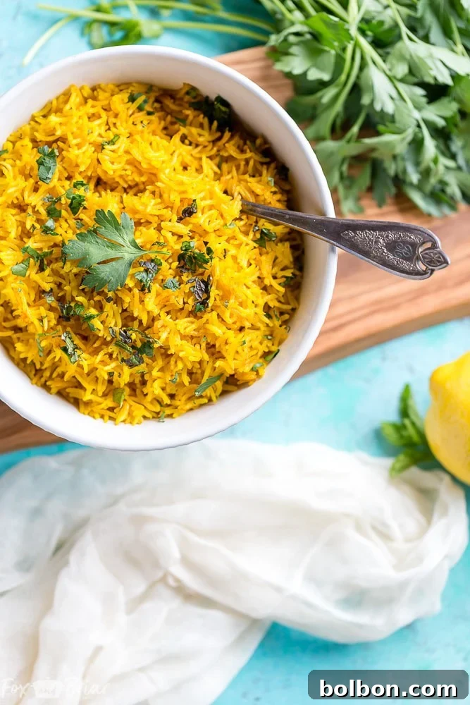 Close-up view of turmeric rice being served, highlighting its fluffy texture and rich golden hue.