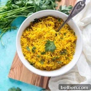 A small bowl of golden turmeric rice with a spoon, highlighting the serving size and appealing texture.