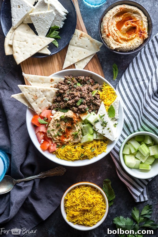 Sun-Kissed Mediterranean Lamb Bowls 2 A beautifully arranged Mediterranean Lamb Bowl featuring spiced ground lamb, turmeric rice, fresh tomatoes, cucumbers, hummus, and feta cheese.