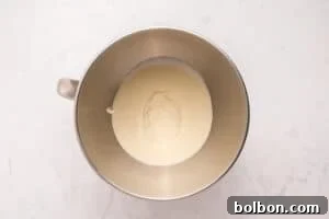 Churning Your Own Golden Butter 5 A metal mixing bowl containing a small amount of thick white cream sits on a light marble surface.