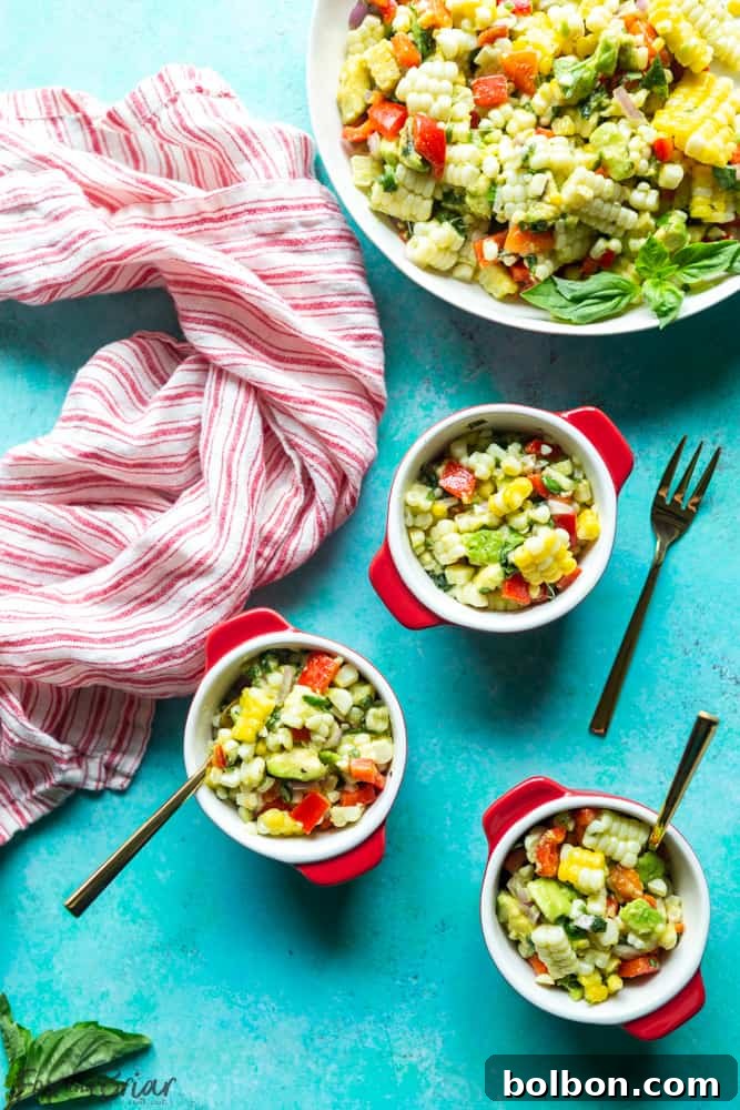 Overhead shot of fresh corn salad in a large white bowl, garnished with fresh basil, ready to be served.