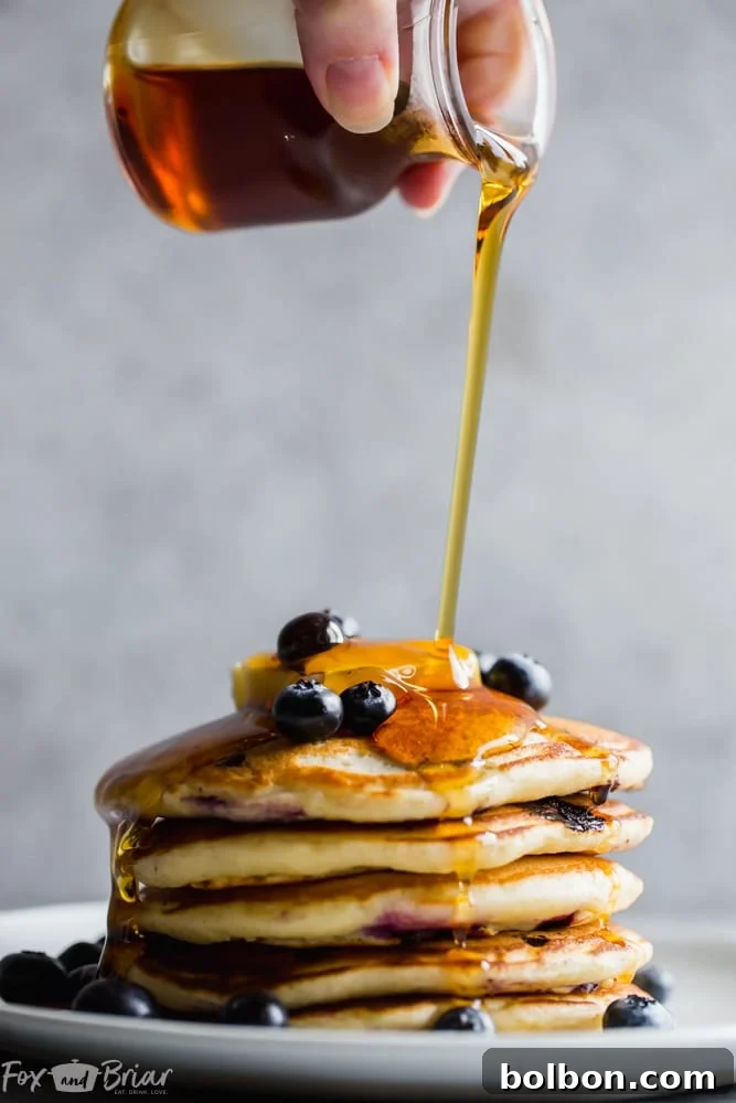 Berry Burst Buttermilk Pancakes 5 A batch of fluffy buttermilk blueberry pancakes cooking on a griddle
