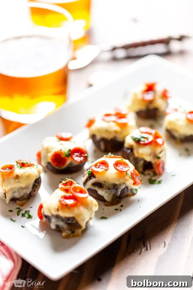 Cheesy Pizza Stuffed Mushrooms 2 Close-up of baked Pizza Dip Stuffed Mushrooms, perfectly golden and bubbly, garnished with fresh parsley.