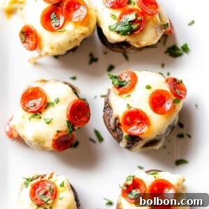 Cheesy Pizza Stuffed Mushrooms 6 Beautifully plated Pizza Dip Stuffed Mushrooms, ready to be served as an appetizer.