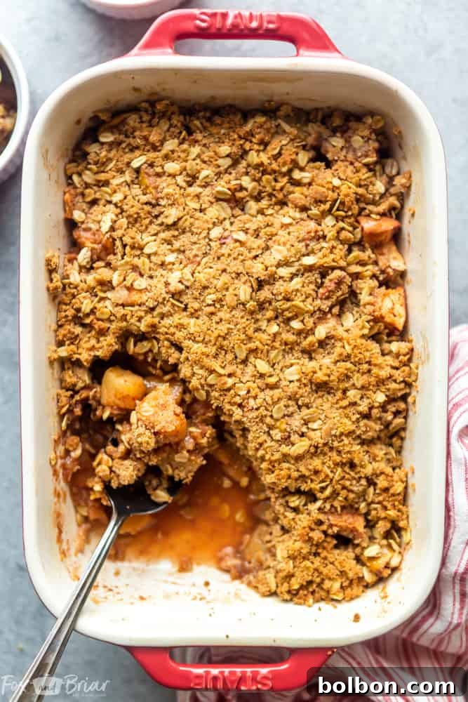 A golden brown easy apple crisp in a baking dish, topped with a delicious oat crumb, ready to be served.