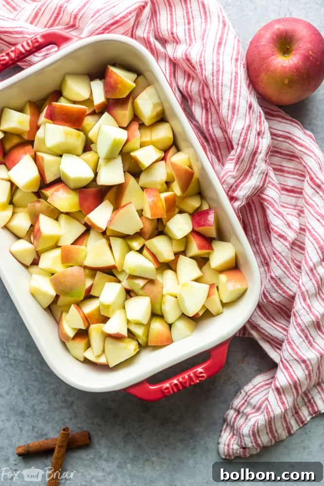 Close-up of freshly diced apples tossed with lemon juice, sugar, and spices, ready for the crisp topping.