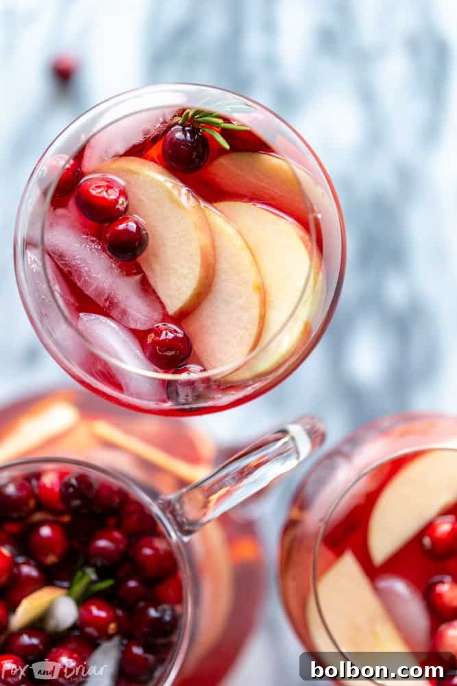 Festive Cranberry Orange Sangria in a pitcher with glasses