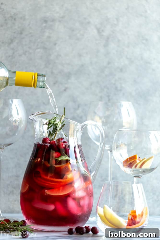 Close-up of Cranberry Orange Sangria with fruit and rosemary garnish