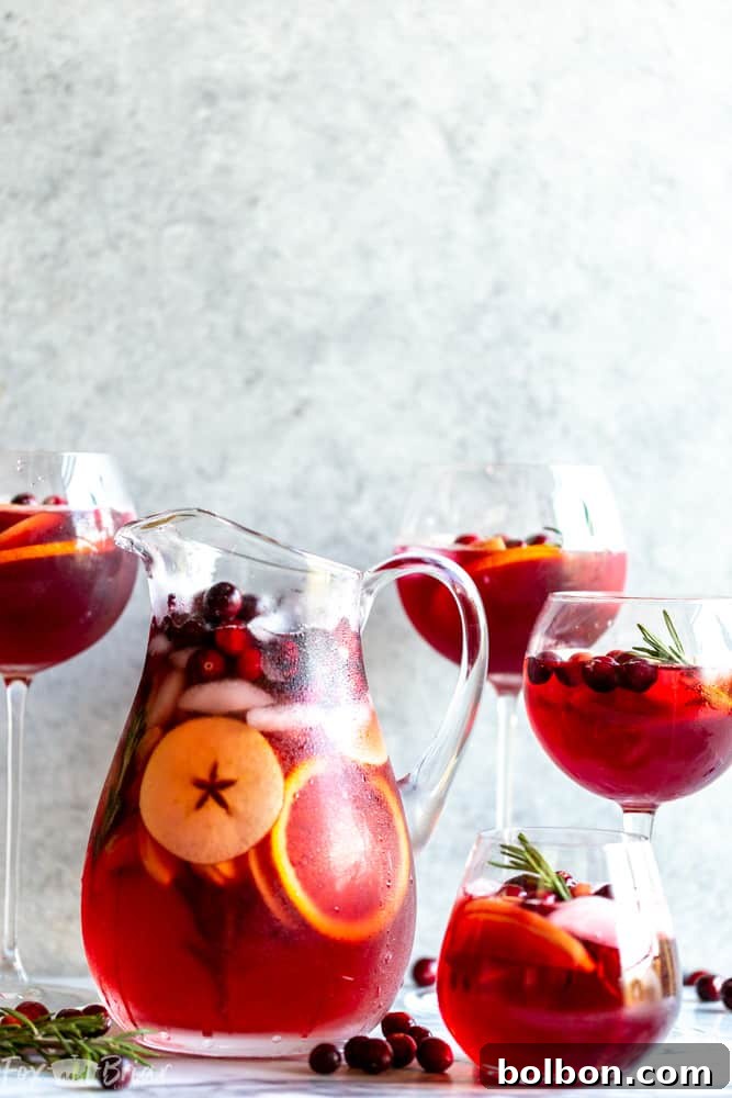Glasses of Cranberry Orange Sangria with pitcher