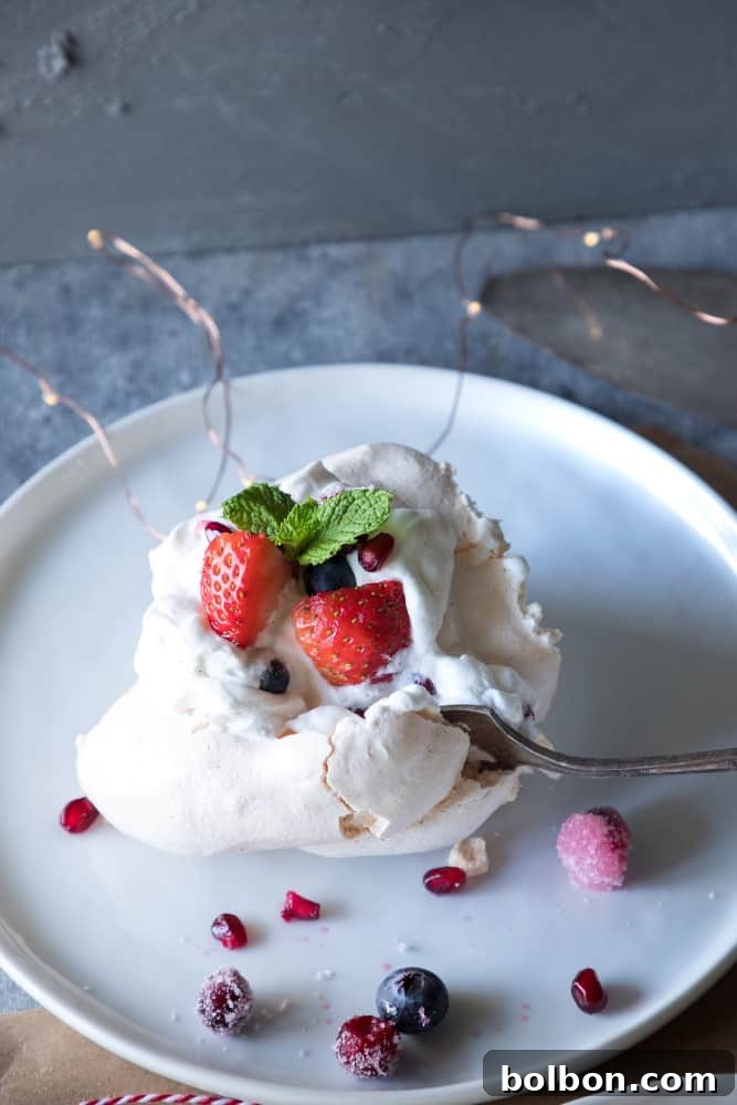 Crafting Your Perfect Pavlova Wreath 7 A stunning Christmas Pavlova Wreath, fully decorated with fresh whipped cream, pomegranate, cranberries, blueberries, strawberries, and mint leaves.