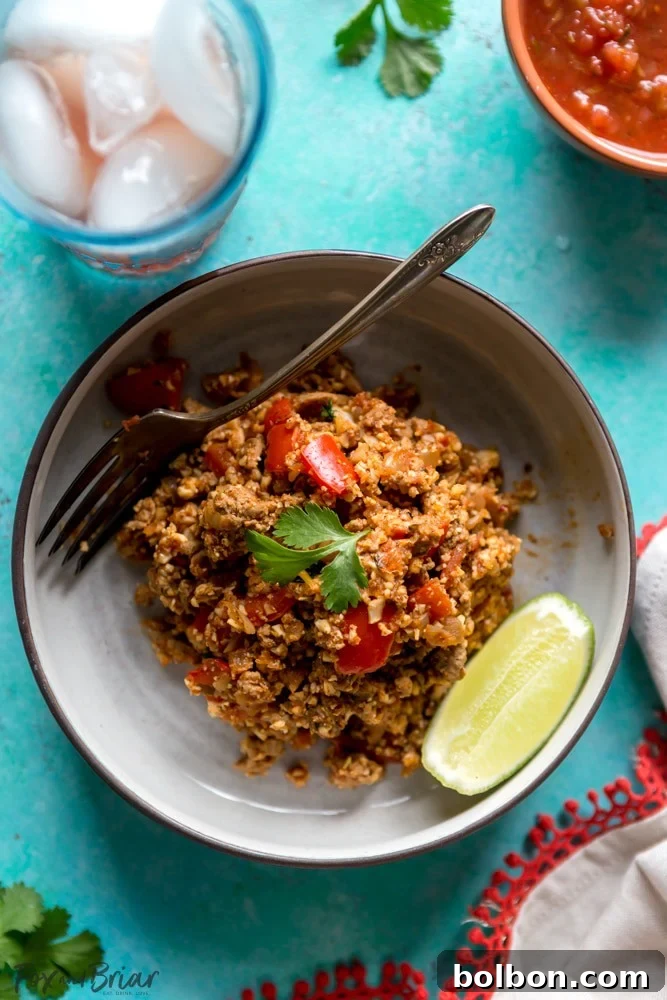 Healthy Cauliflower Rice Turkey Taco Skillet topped with fresh cilantro and lime