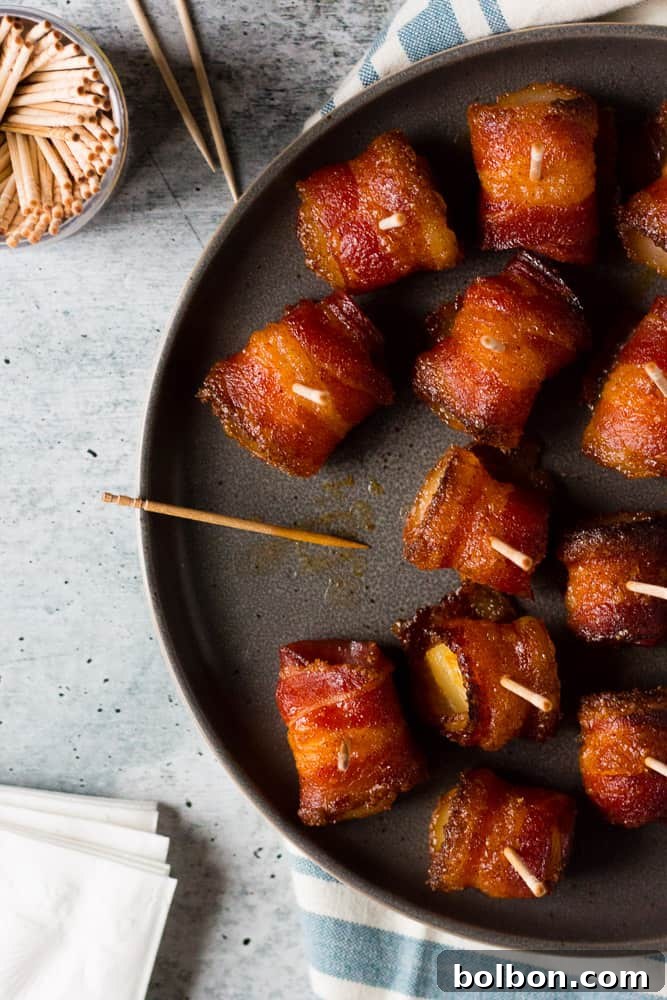 Close-up of perfectly baked brown sugar bacon wrapped pineapple bites, showing the caramelized sugar